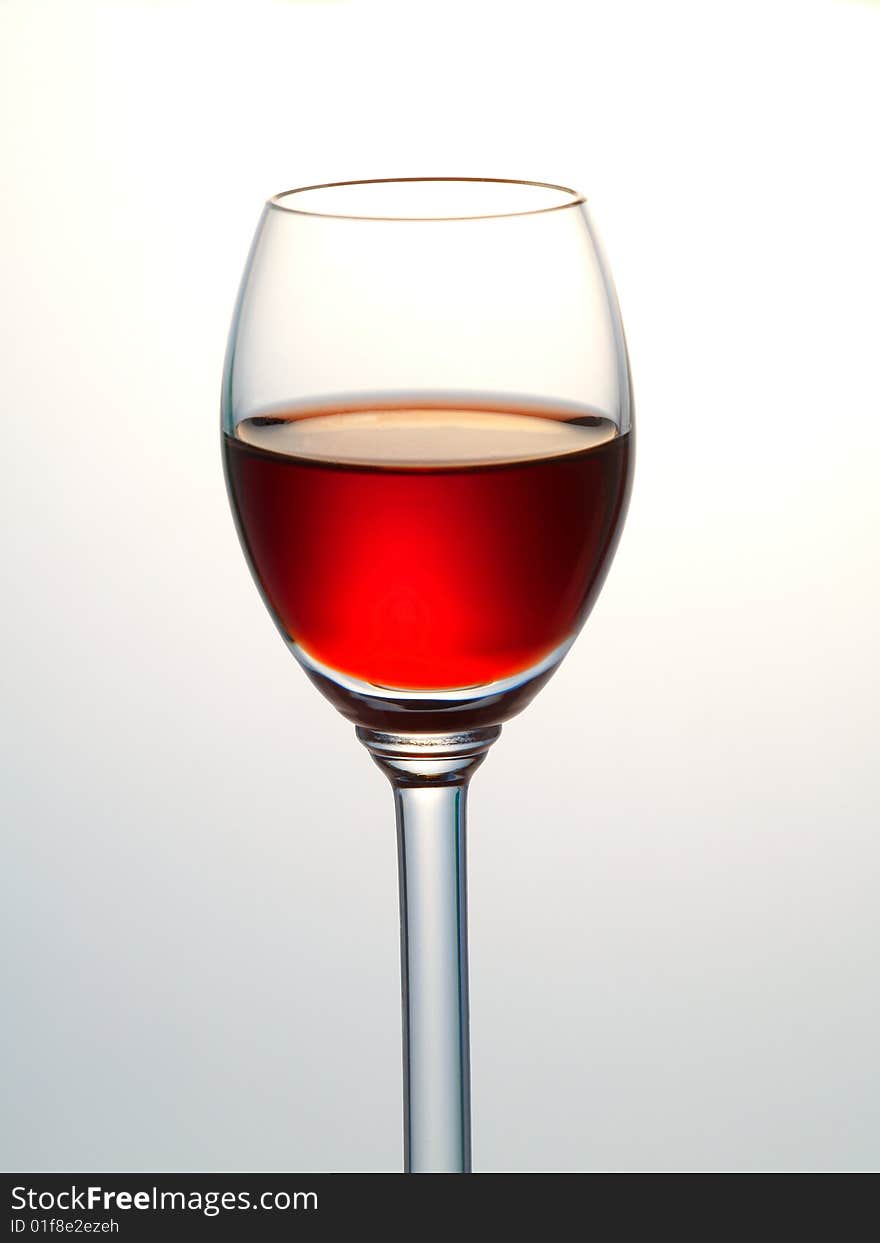 Small glass filled with red liquor. Small glass filled with red liquor