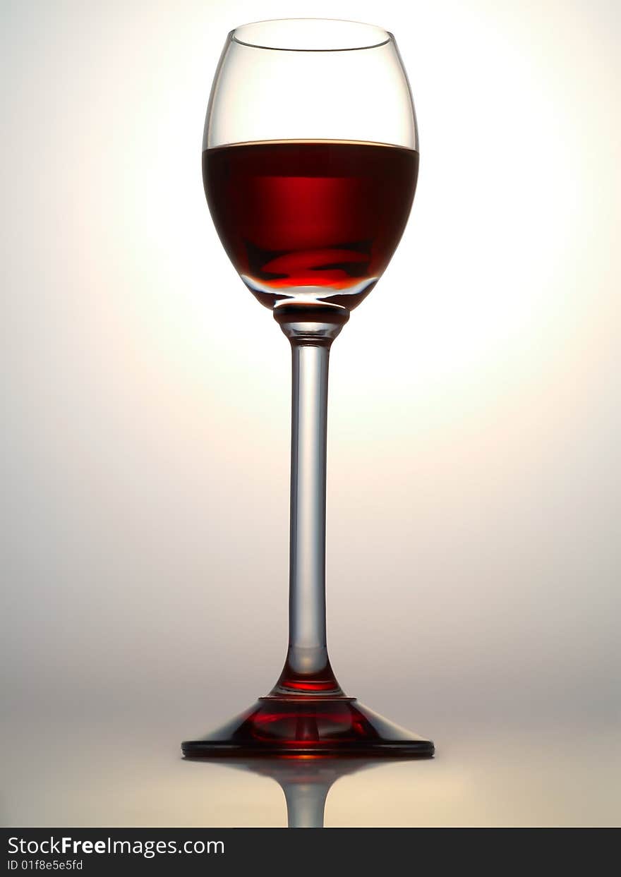 Small glass filled with dark red liquor. Small glass filled with dark red liquor