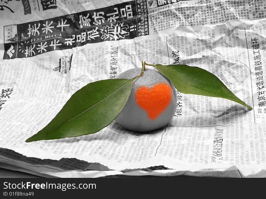 Tangerine with green slip on chinese newspaper