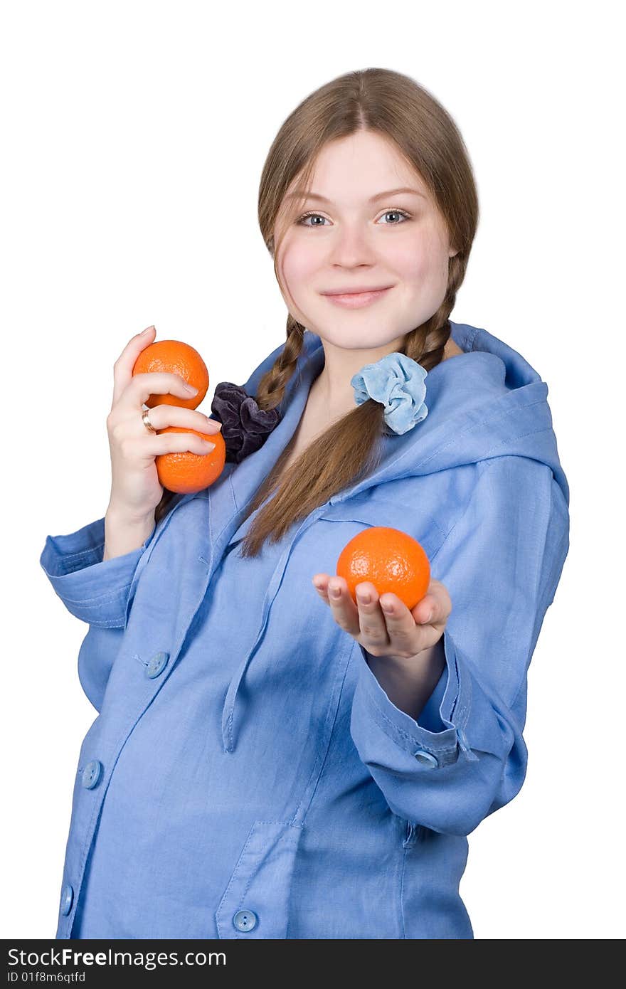 Fine pregnant woman in blue holding three oranges on white background