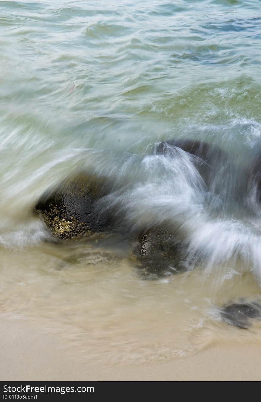 Wave crashing on rocks during the ebbing tide. Wave crashing on rocks during the ebbing tide