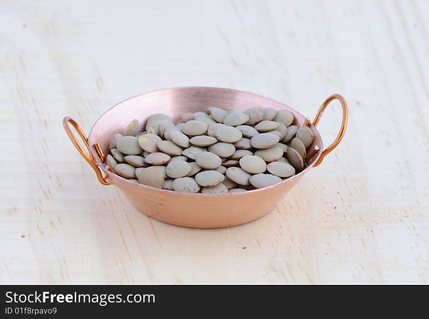 Picture of frying pan isolated in background of wood with lentils. Picture of frying pan isolated in background of wood with lentils