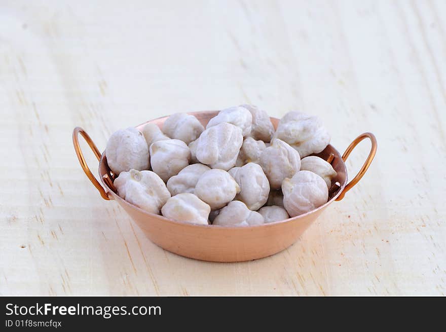 Picture of frying pan isolated in background of wood with chickpea. Picture of frying pan isolated in background of wood with chickpea