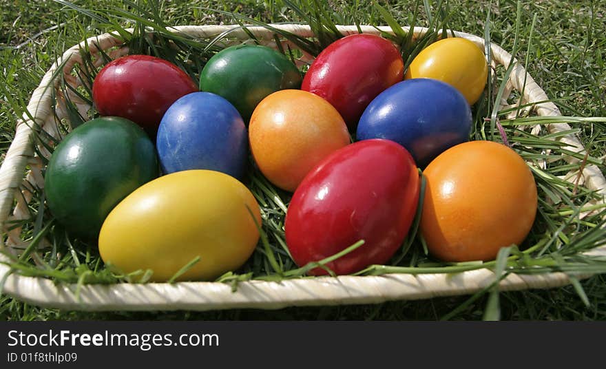 Easter eggs on a bascket with different color on the grass