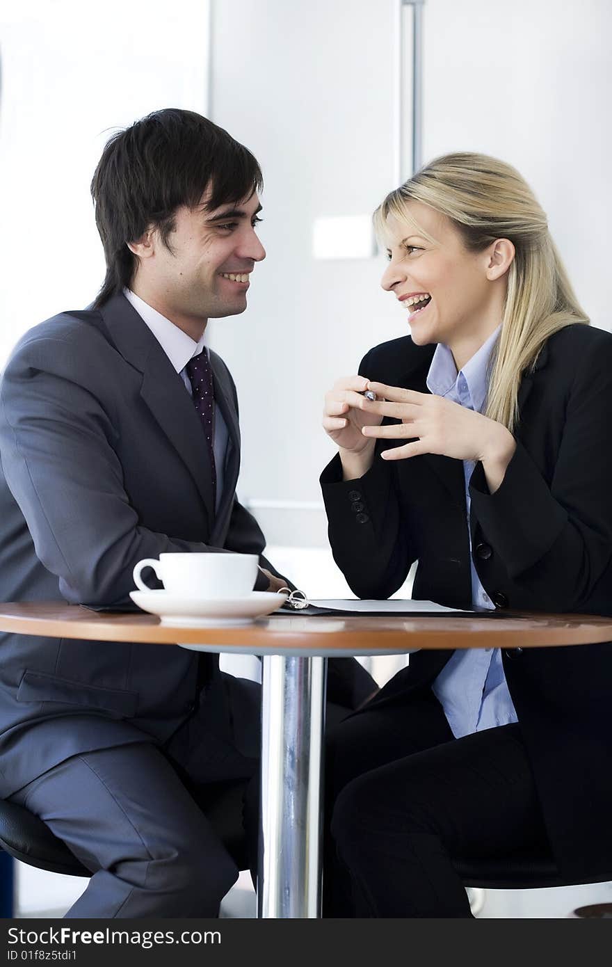 Two business people discussing a project over a cup of coffee. Two business people discussing a project over a cup of coffee