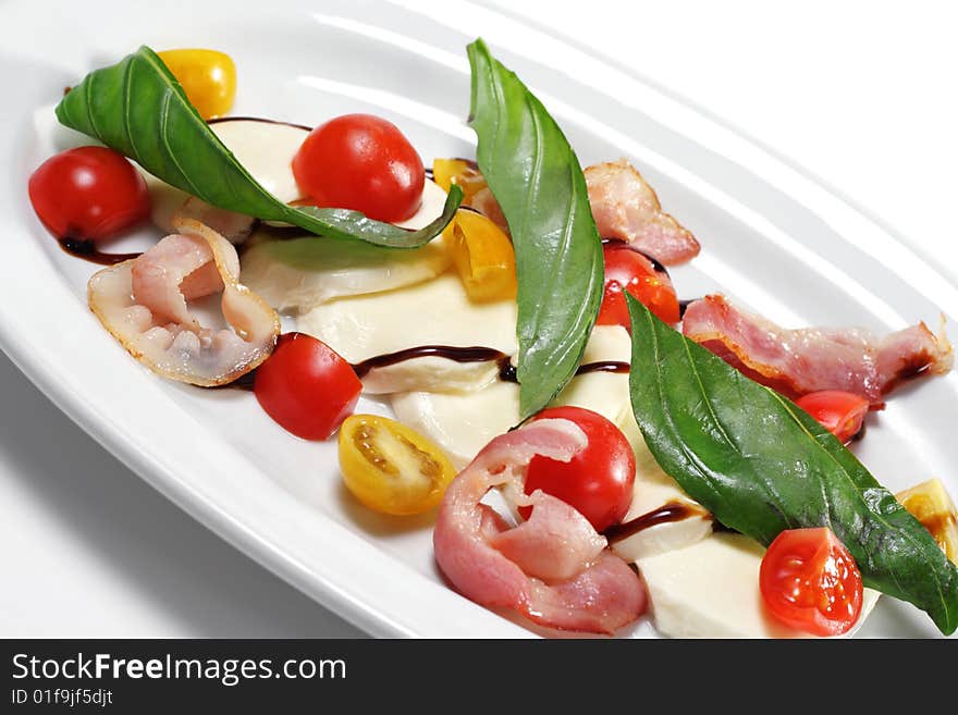 Salad with Cherry Tomato, Buffalo Cheese, Bacon and Vegetable Leaf. Isolated on White Background. Salad with Cherry Tomato, Buffalo Cheese, Bacon and Vegetable Leaf. Isolated on White Background