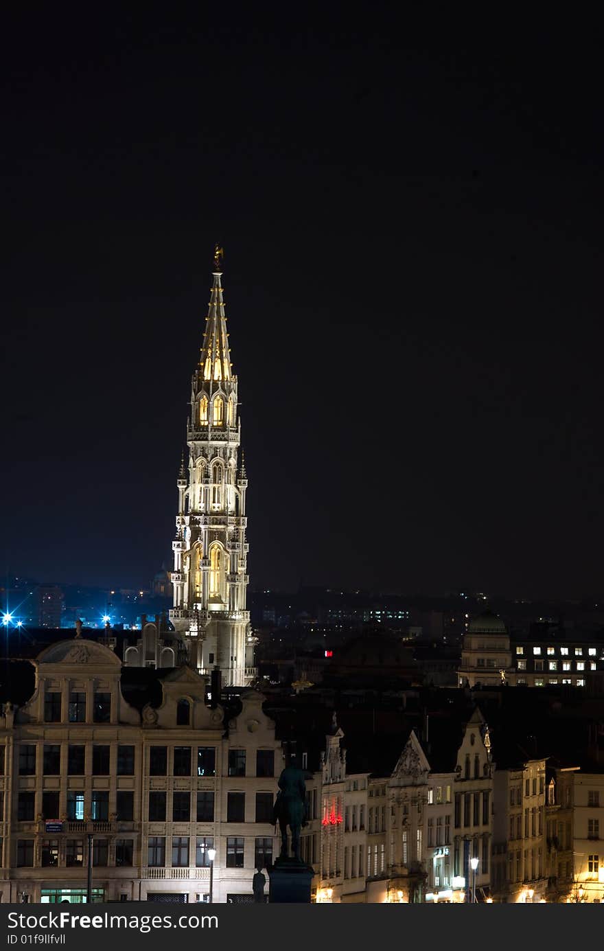 The 96 meter high belfry of Brussels townhall with a five meter high metal statue of archangel Michael patron saint of Brussels faraway photographed at night. The 96 meter high belfry of Brussels townhall with a five meter high metal statue of archangel Michael patron saint of Brussels faraway photographed at night