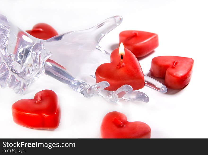 Red heart shaped candle and glass or ice hand holding a burning candle (Fragility of Love concept)