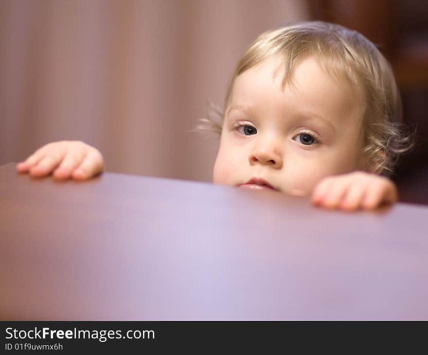 Little girl looking out of a table - shallow DOF