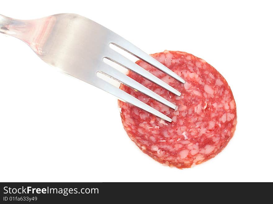 Piece of the sausage on the fork under the white background