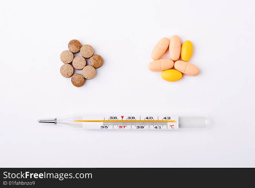 Pills piles with a thermometer