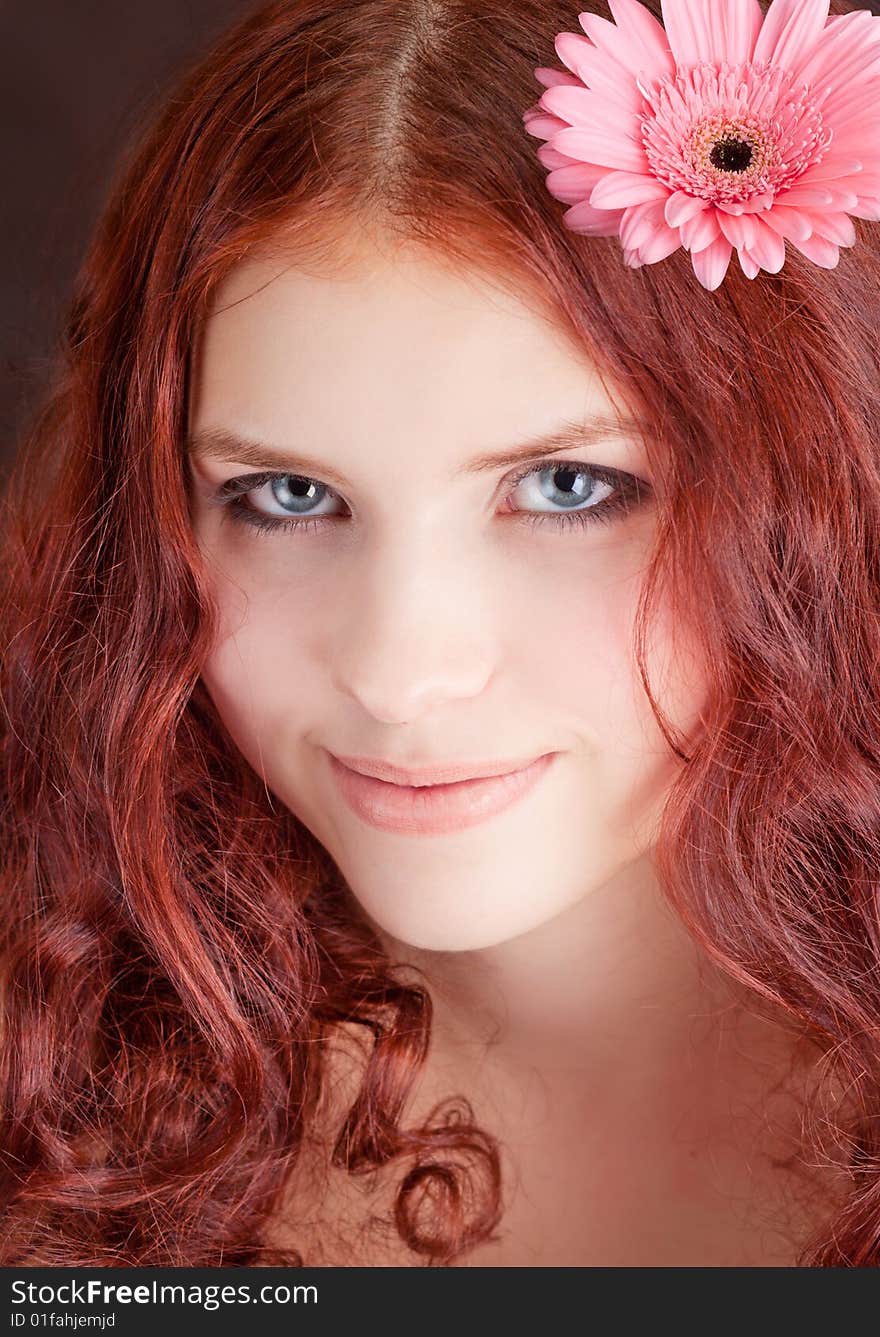 Young beautiful girl with a flower in hair