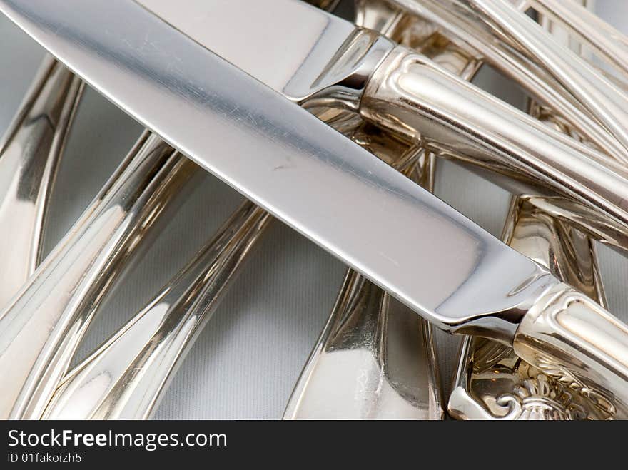 A mix of silver flatware on a white background. A mix of silver flatware on a white background