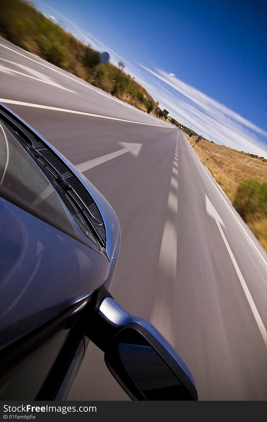 Cruising the countryside in a blue car at high speed.