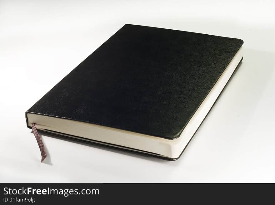 One black notebook with soft shadow on white background. One black notebook with soft shadow on white background