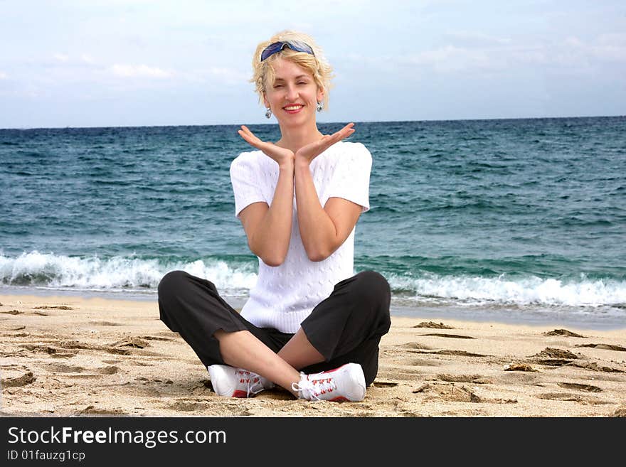 Blond girl meditating by the sea