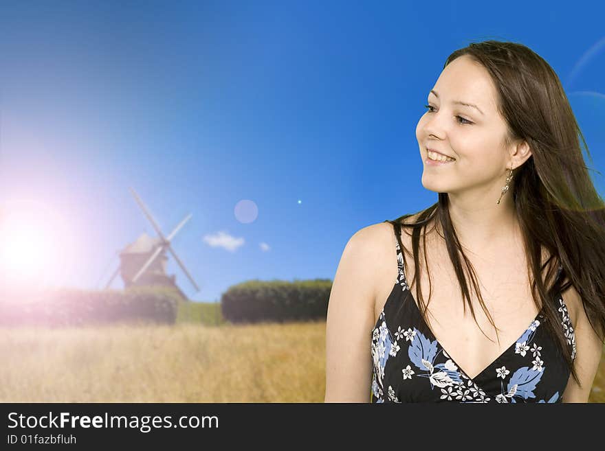 Girl over windmill in wide field in brittany in france