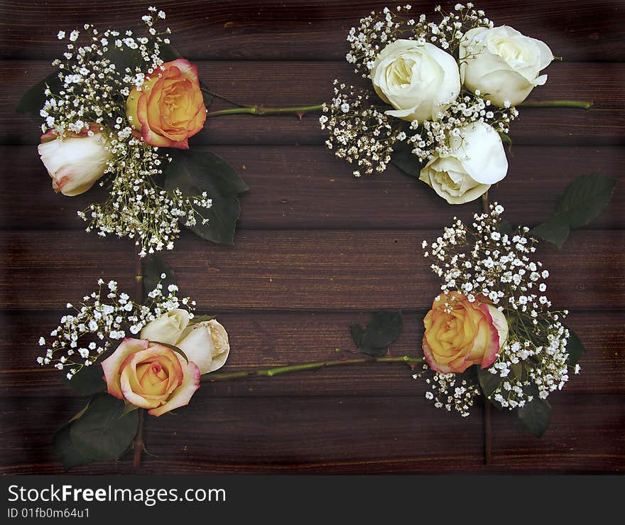 Roses and Baby's breath form a frame on an old wall of barn wood. Roses and Baby's breath form a frame on an old wall of barn wood