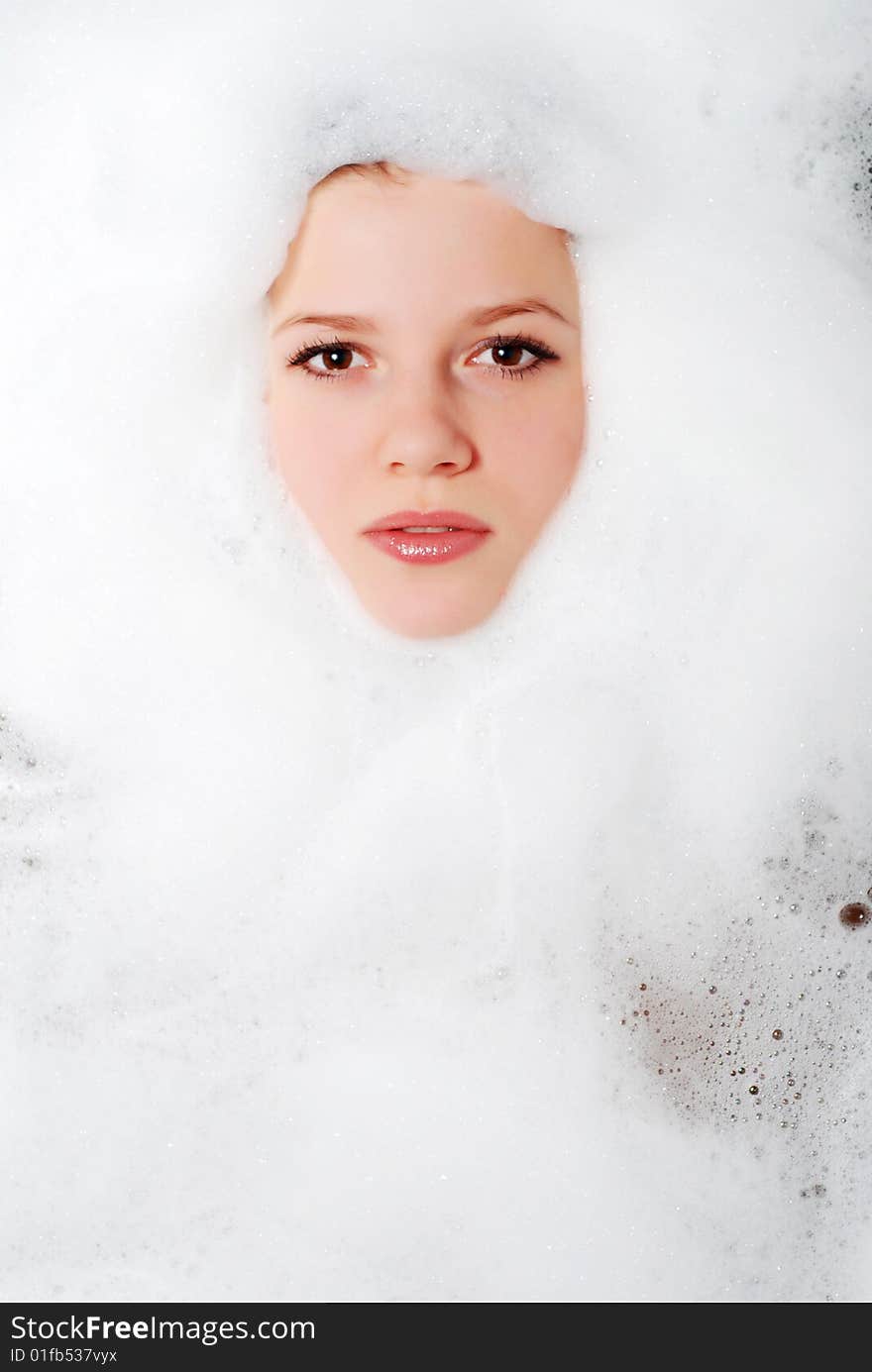 Face of a beautiful woman in white foam. Face of a beautiful woman in white foam