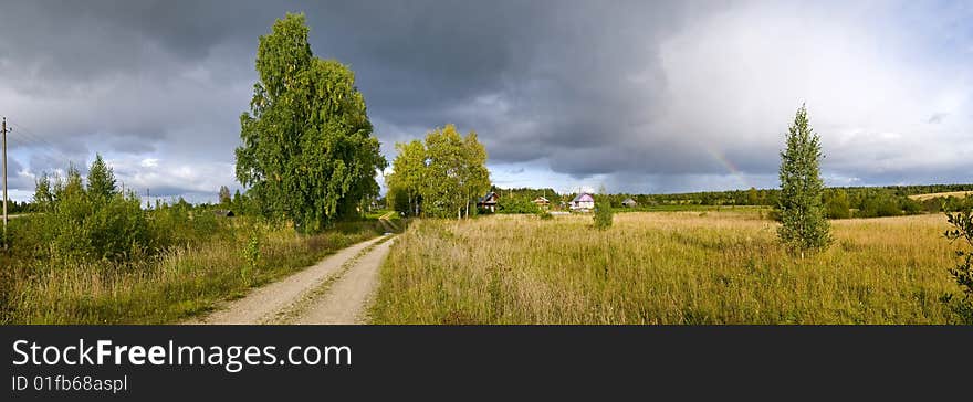 Rainbow on background of the rural landscape