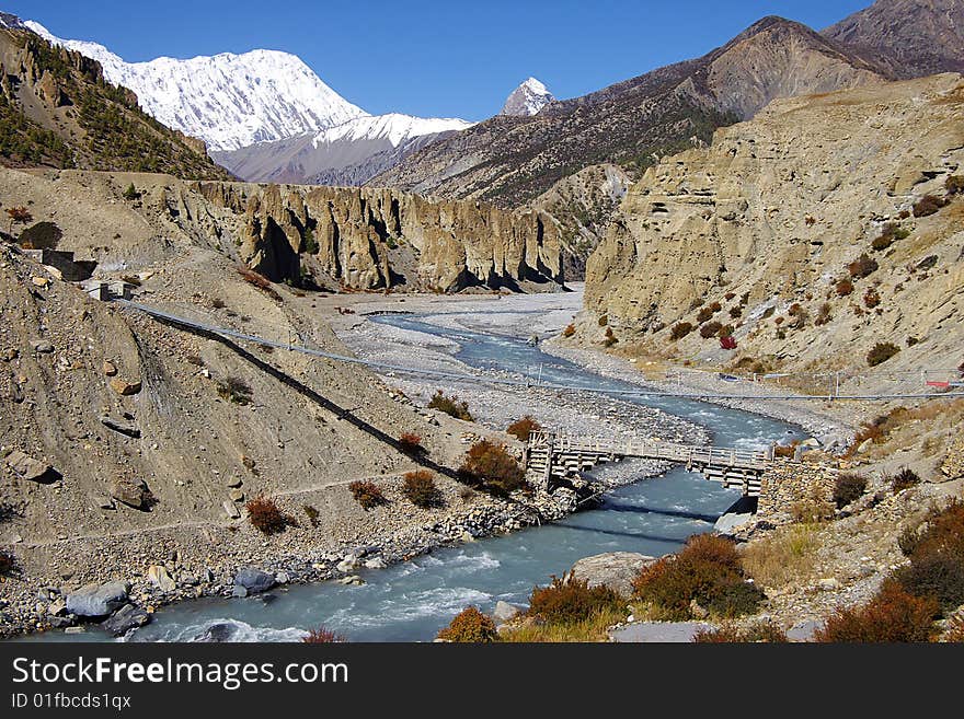 On a photo: Picturesque nepalese landscape with bridge