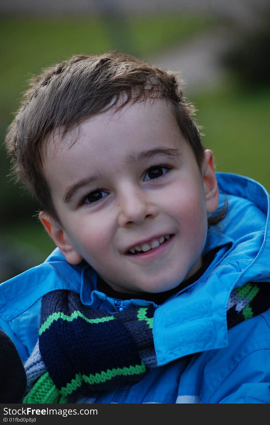 Boy in a blue jacket in an autumn park