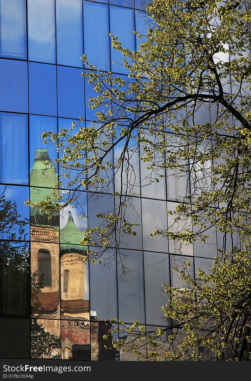 The old church is reflected in a modern building