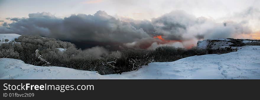 Beautiful winter evening landscape in the field of snow at dusk