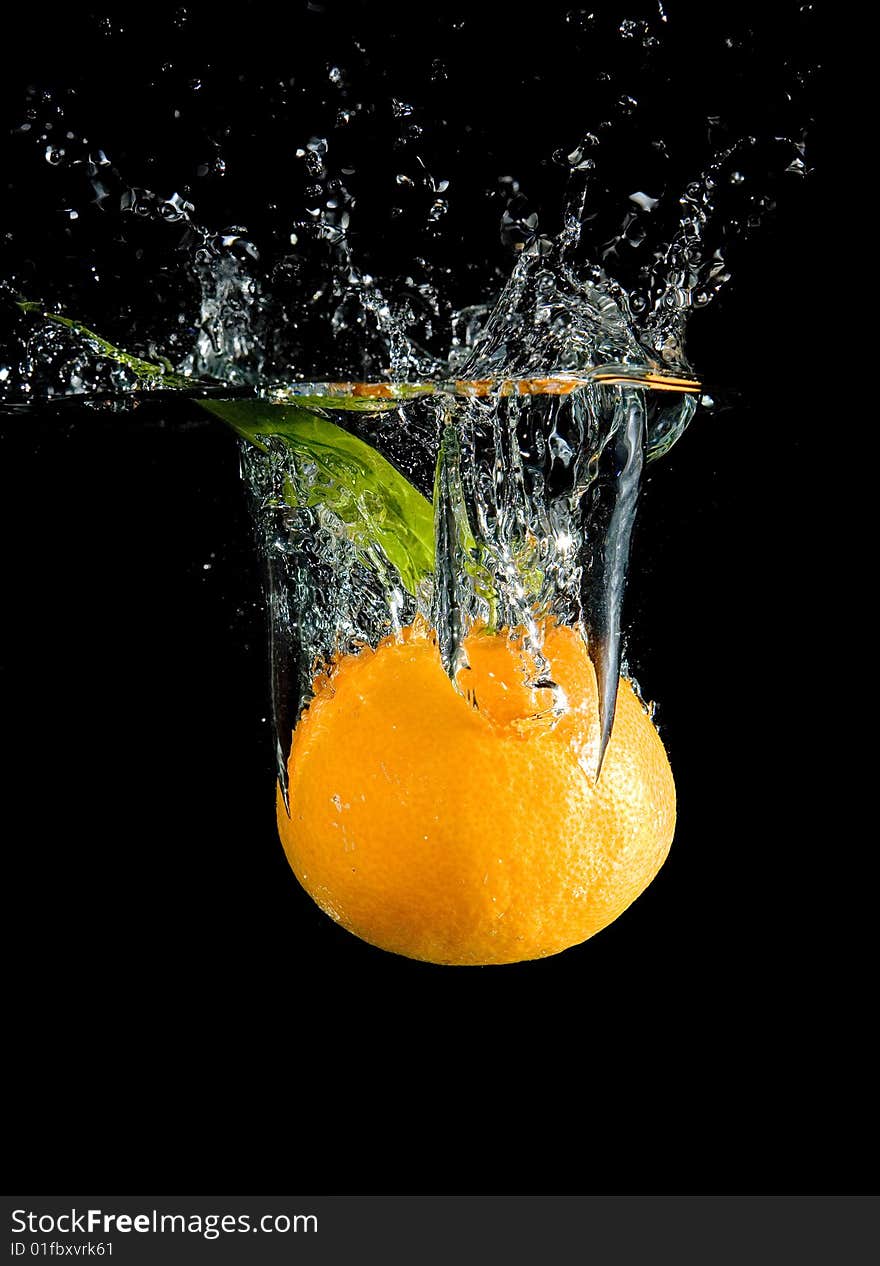 Tangerine in water with bubbles on black ground. Tangerine in water with bubbles on black ground