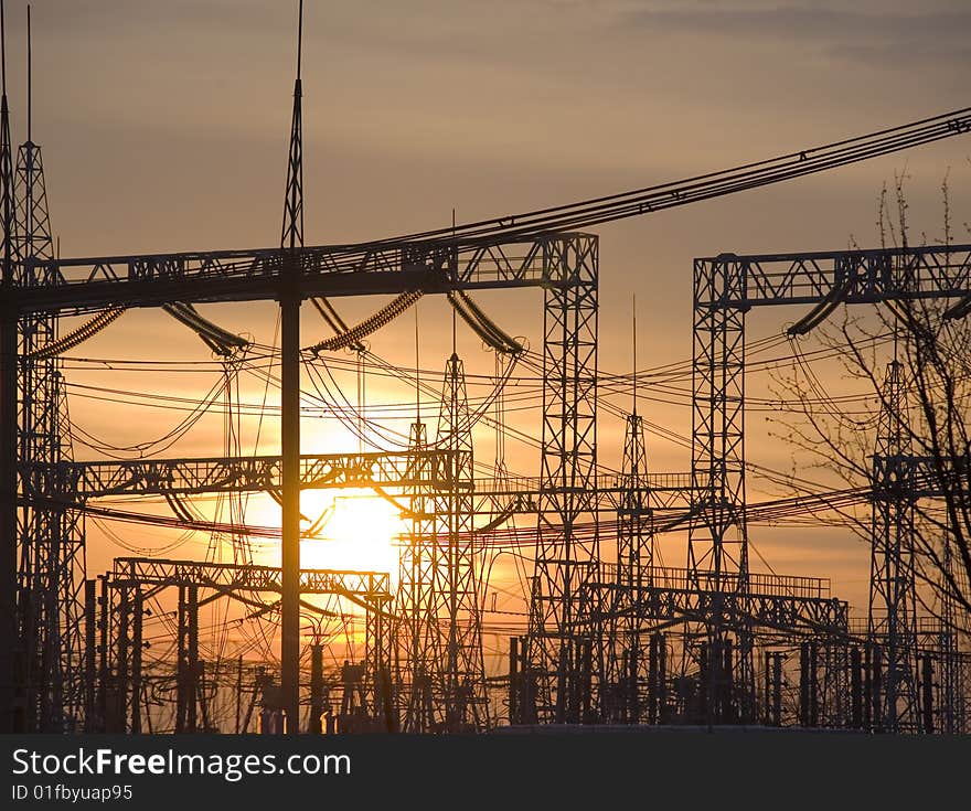 Sun setting behind a row of electricity pylons. Sun setting behind a row of electricity pylons