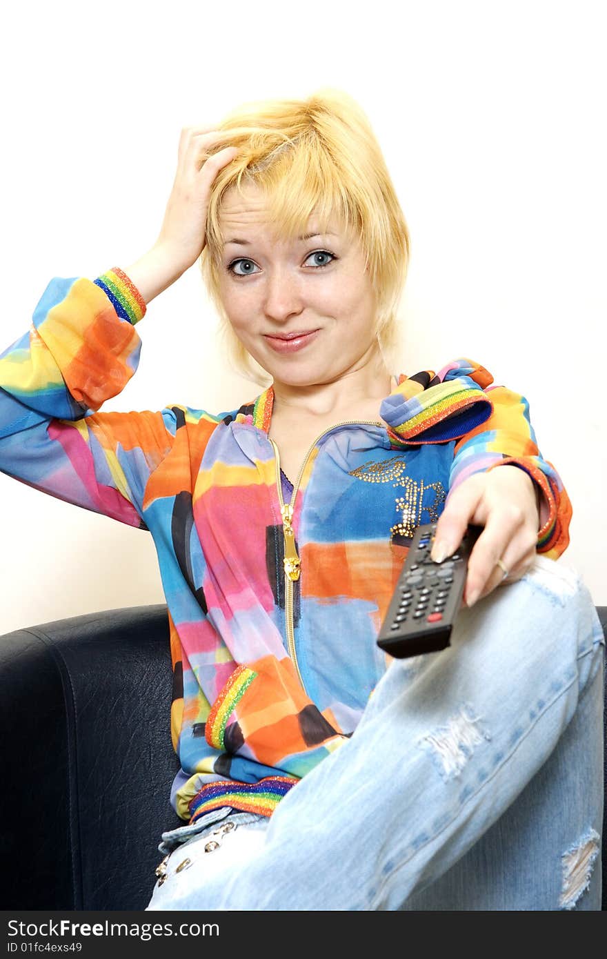 Female in blue jeans sitting on the sofa and watching TV