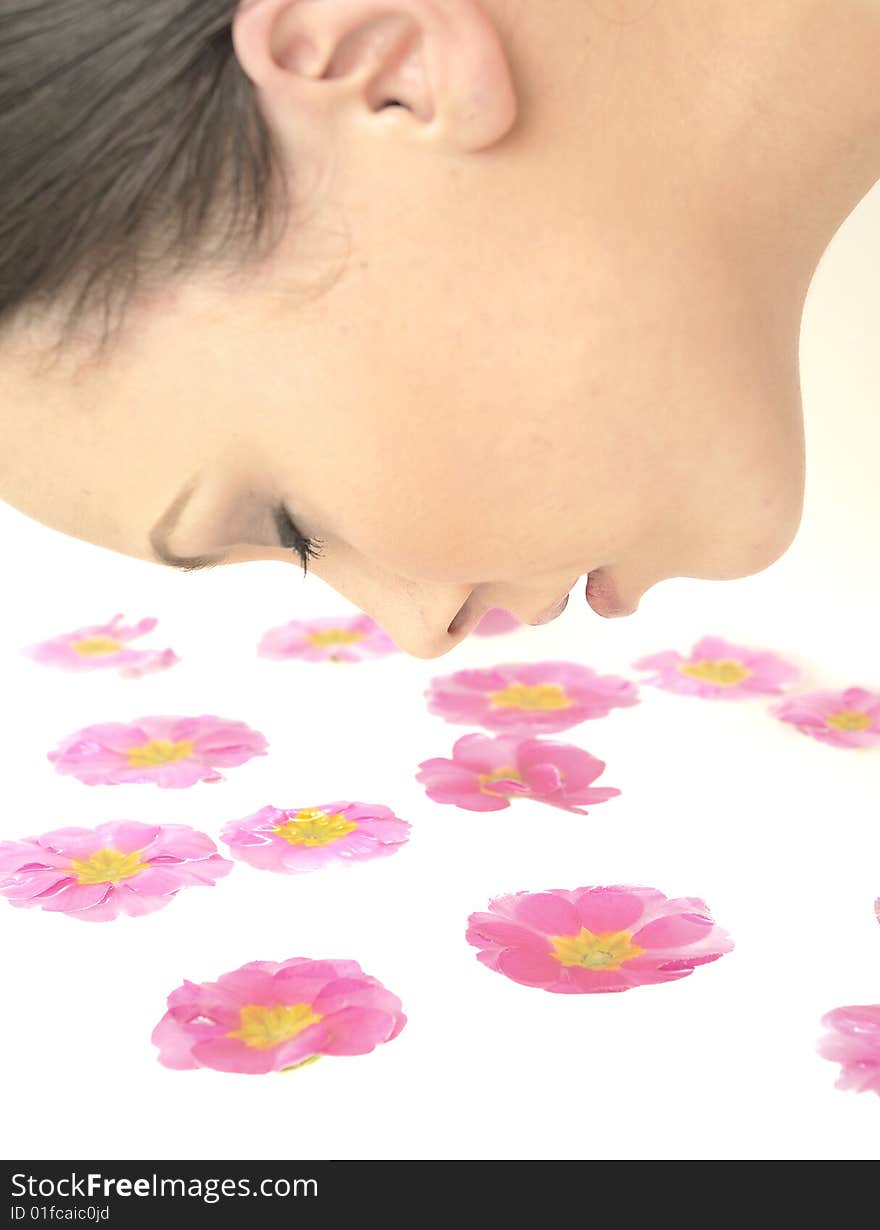 Beautiful girl relaxing and smelling the flower petals in spa. Beautiful girl relaxing and smelling the flower petals in spa