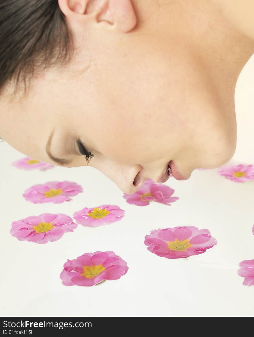 Beautiful girl relaxing and smelling the flower petals in spa. Beautiful girl relaxing and smelling the flower petals in spa