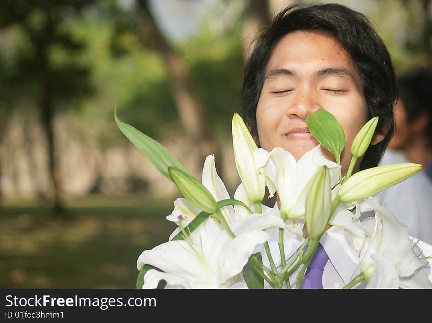 A guy smelling flowers in the garden. The smell of sucess!