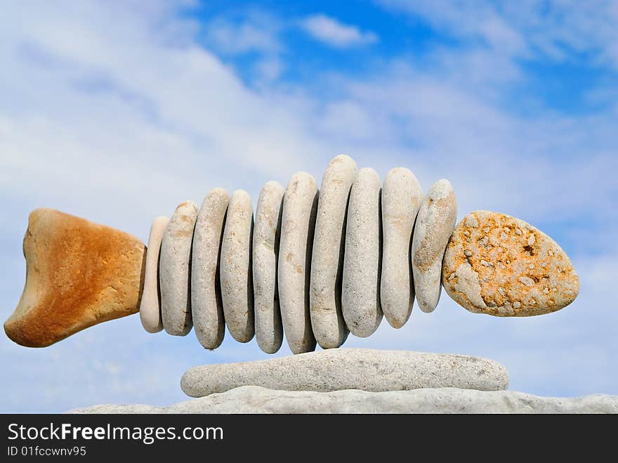 Sea pebble combined in the form of fish on a beach. Sea pebble combined in the form of fish on a beach