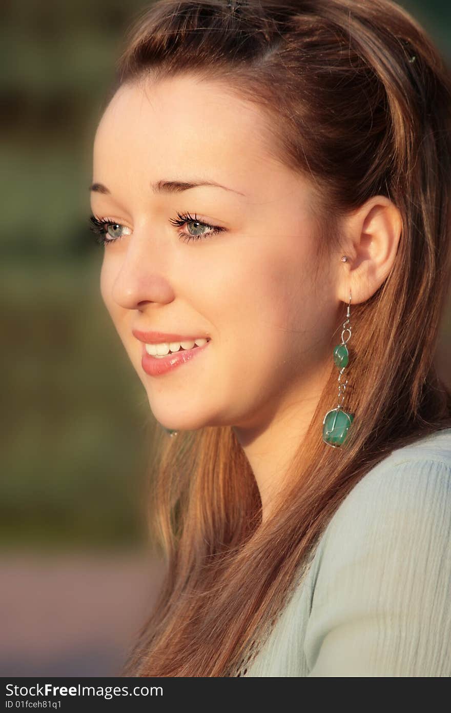 Portrait of a beautiful young lady in golden light of summer sunset