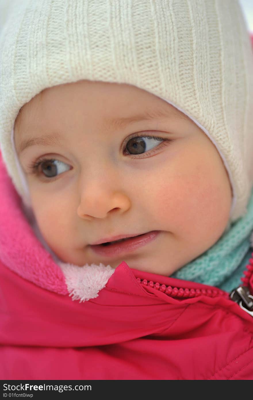 Little girl in white hat in winter