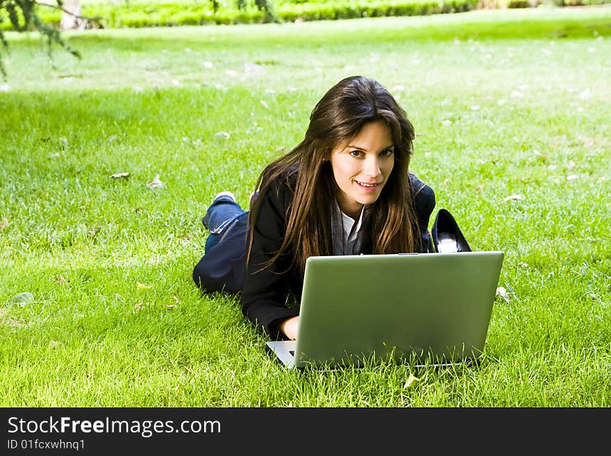 Young happy businesswoman working on the grass. Young happy businesswoman working on the grass