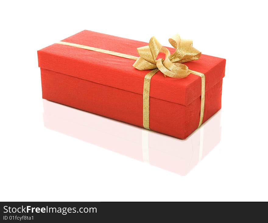 Red gift box over white background with gold ribbon