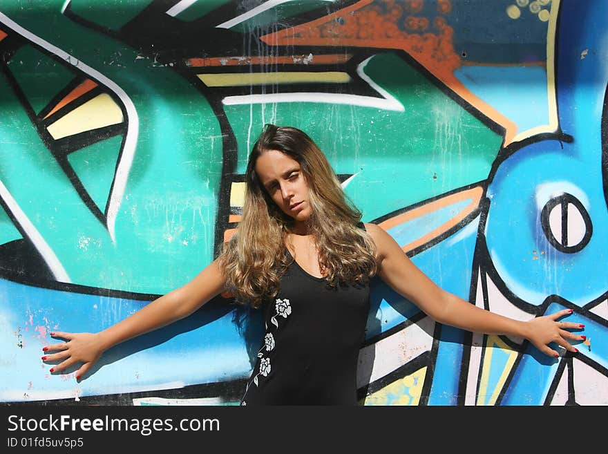 Woman with open arms in a wall with graffiti