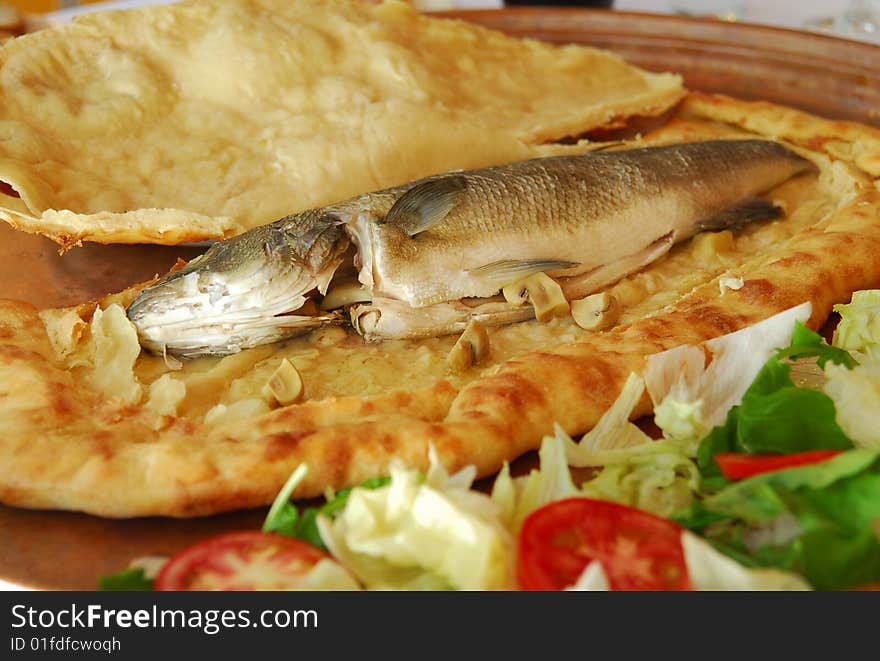 traditional turkish and mediterranean seafood, Sea bass in cooking in the pitta serving with wine or turkish traditional drink raki. traditional turkish and mediterranean seafood, Sea bass in cooking in the pitta serving with wine or turkish traditional drink raki