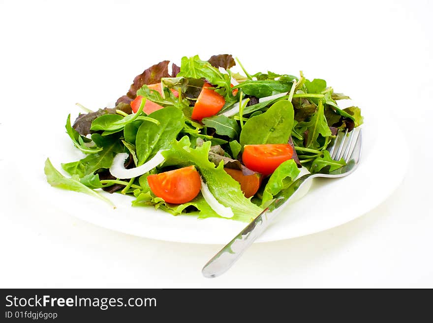 Fresh salad with fork on white background