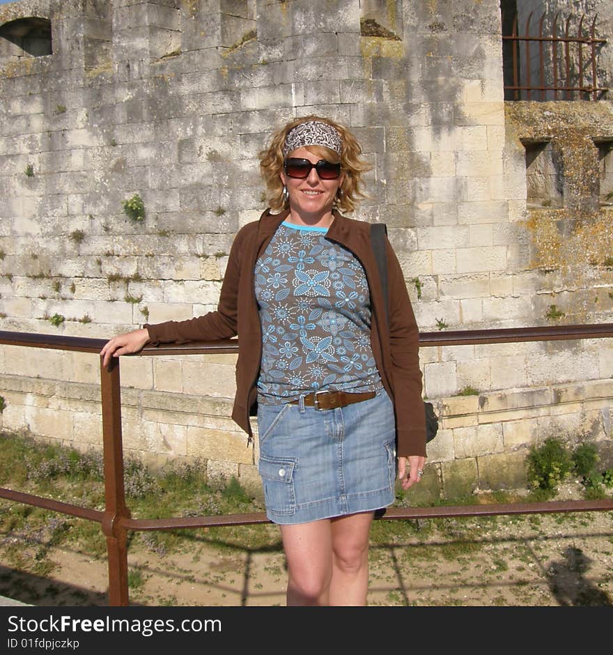 A woman tourist is posing in front of a landmark on vacation. A woman tourist is posing in front of a landmark on vacation