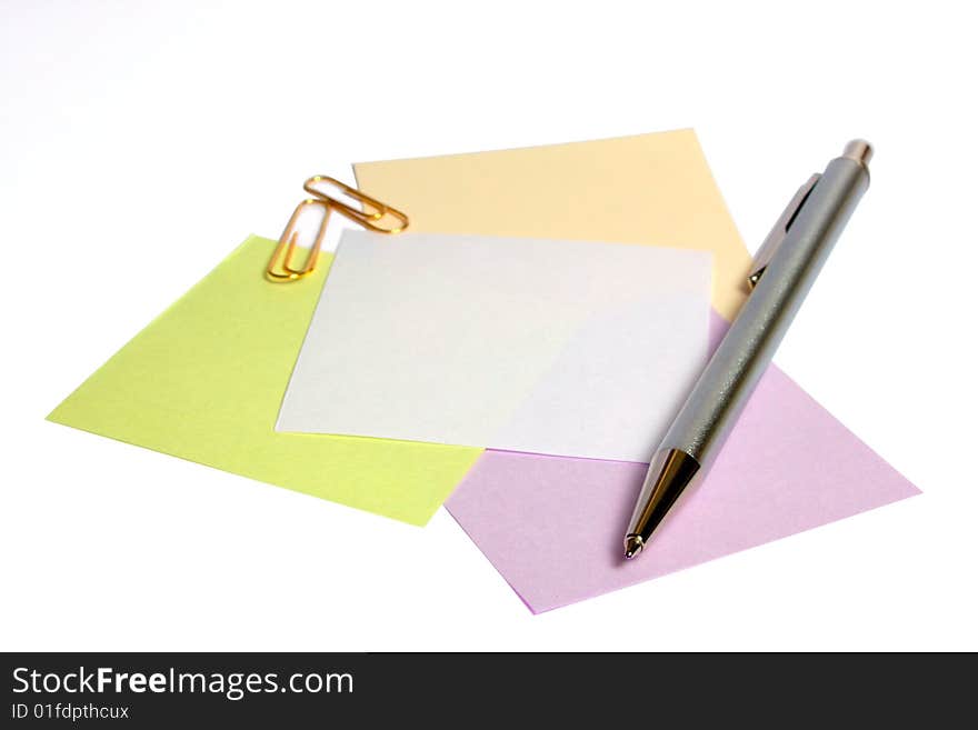 Pen and paper clips on a heap of notes on white it is isolated. Pen and paper clips on a heap of notes on white it is isolated