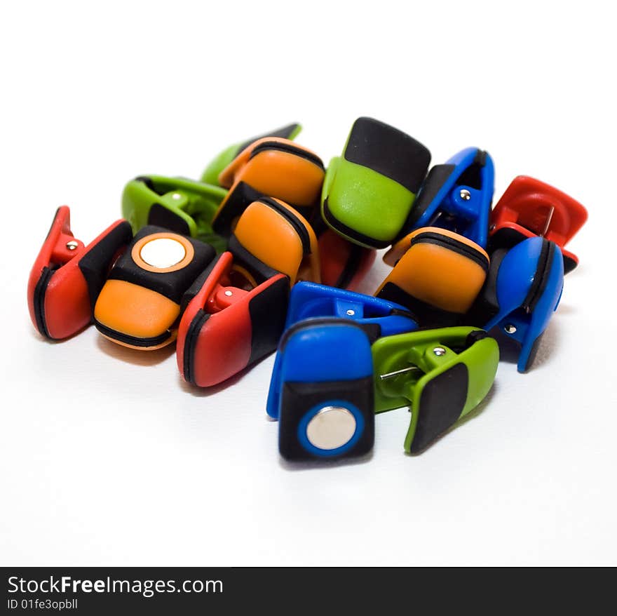 Cluster of colorful magetic clips on white background. Cluster of colorful magetic clips on white background.