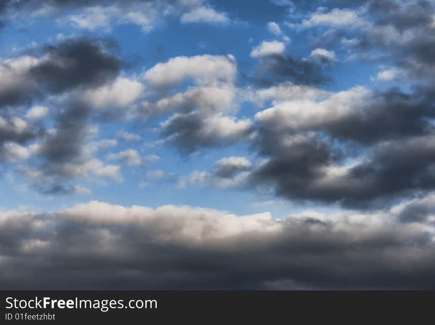 Blue sky background with white and dark clouds