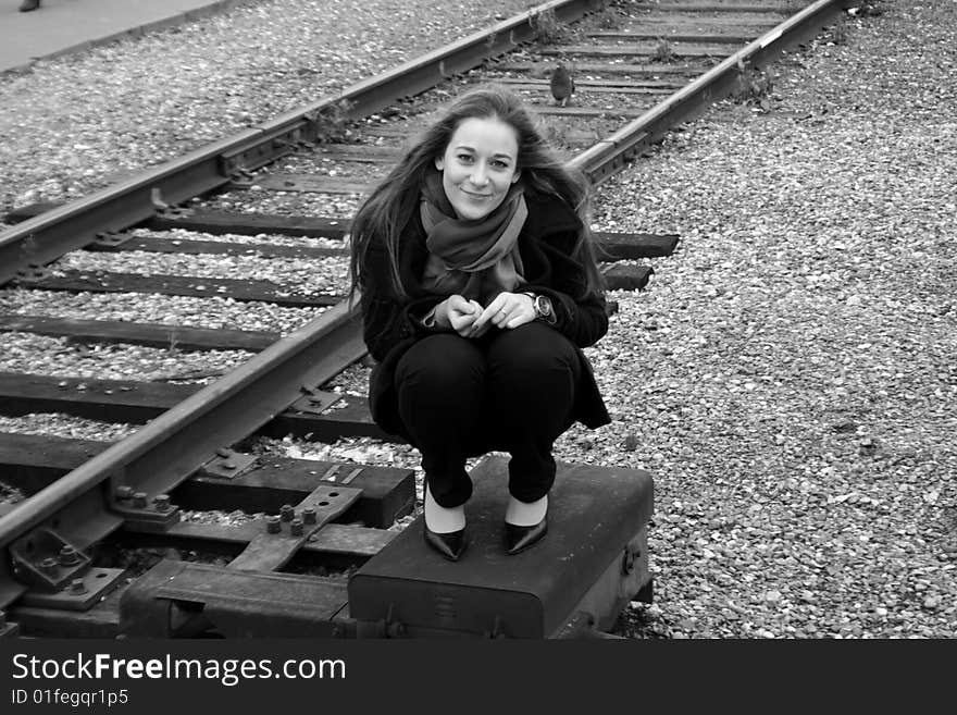 Girl sitting near railroad