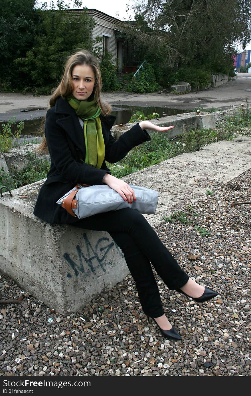 A girl sitting on a stone. A girl sitting on a stone