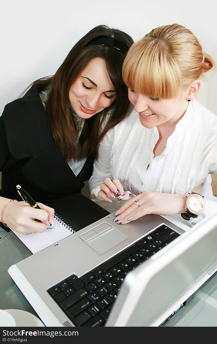 Two young business partners working in office. . Two young business partners working in office.