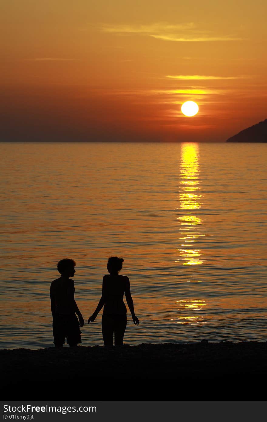 A silhouette of a pair in the sunset